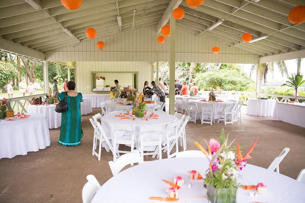 Wedding Reception Tables and Chairs Setup with tropical flowers as centerpieces at Molii Venue in Kualoa Ranch